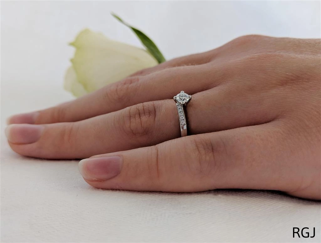The Dursey Platinum 0.22ct Round Brilliant Cut Diamond Solitaire Engagement Ring With 0.10ct Diamond Set Shoulders