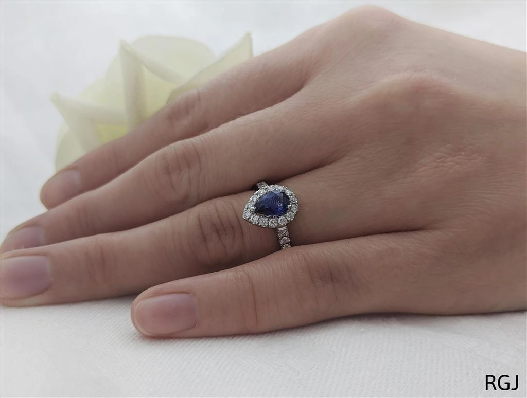 The Evie Platinum 0.77ct Pear Cut Blue Sapphire Ring With 0.44ct Diamond Halo And Diamond Set Shoulders