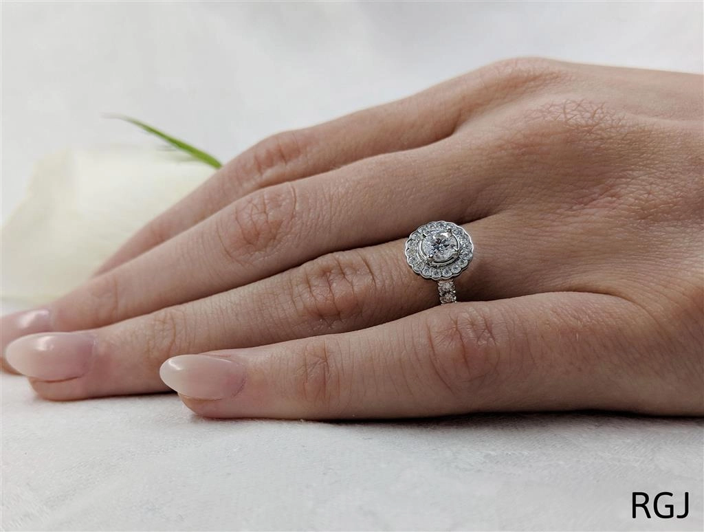 The Faroe Platinum 0.40ct Round Brilliant Cut Diamond Engagement Ring With 0.30ct Scalloped Diamond Halo And Diamond Set Shoulders