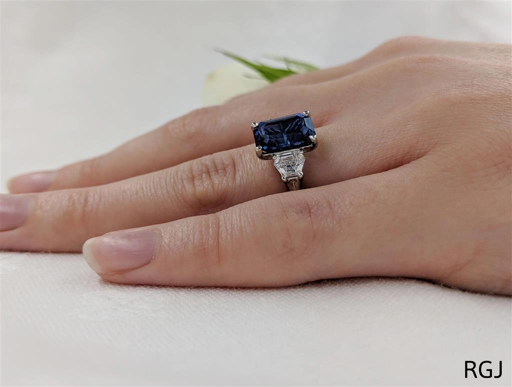 The Florentine Platinum 3.32ct Emerald Cut Blue Sapphire And 0.63ct Tapered Diamond Three Stone Ring