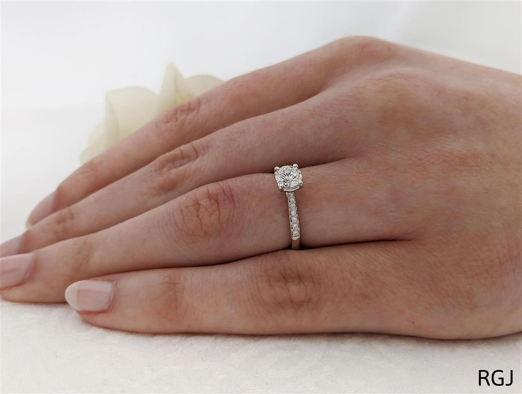 The Memoire Aura Platinum 0.50ct Round Brilliant Cut Diamond Solitaire Engagement Ring With 0.13ct Diamond Set Shoulders