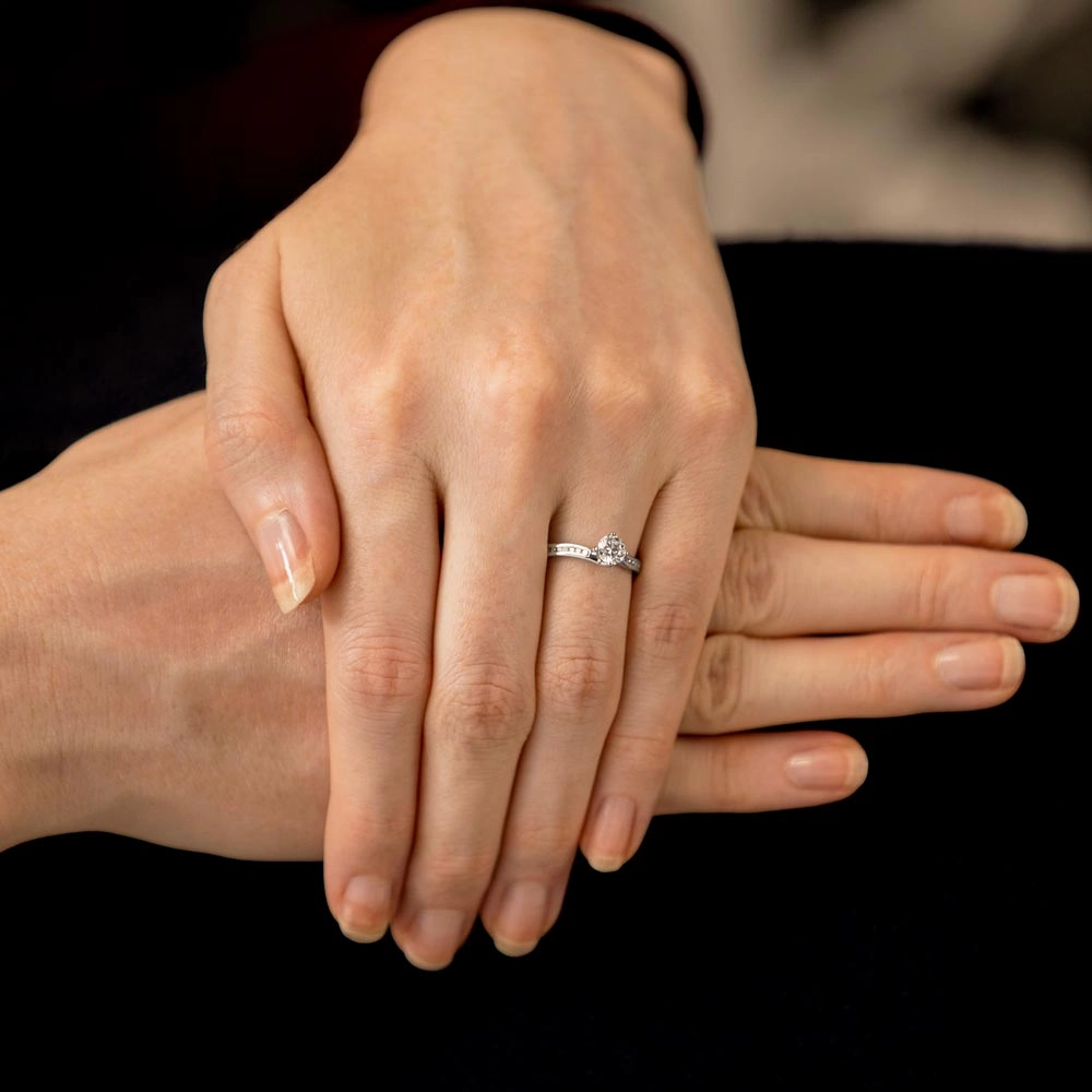 The Rose Platinum Round Brilliant Cut Diamond Solitaire Engagement Ring With Channel Set Diamond Shoulders