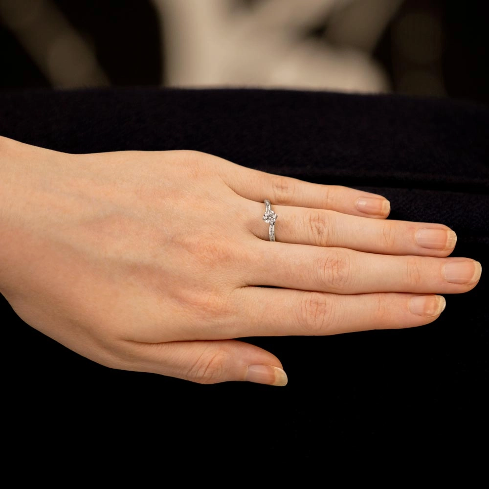 The Rose Platinum Round Brilliant Cut Diamond Solitaire Engagement Ring With Channel Set Diamond Shoulders