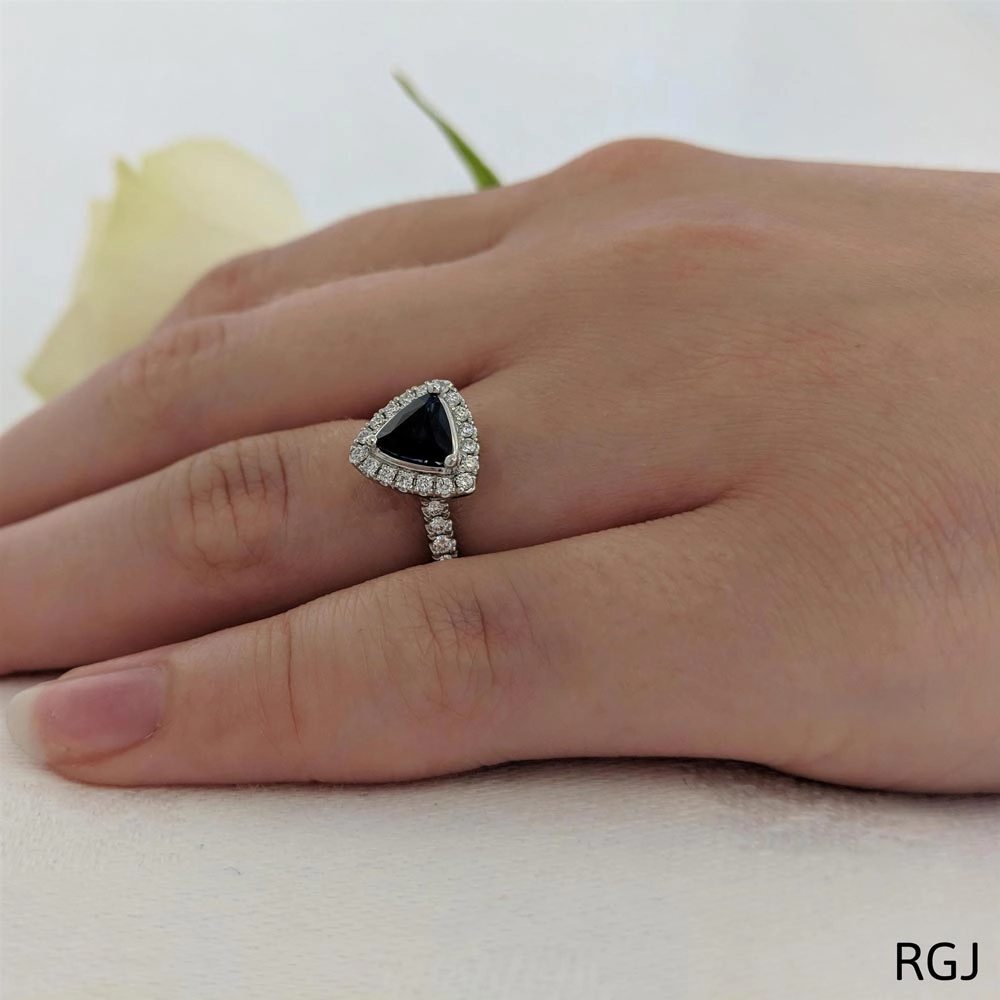 The Skye Platinum 0.84ct Trilliant Cut Blue Sapphire Ring With 0.33ct Diamond Halo And Diamond Set Shoulders