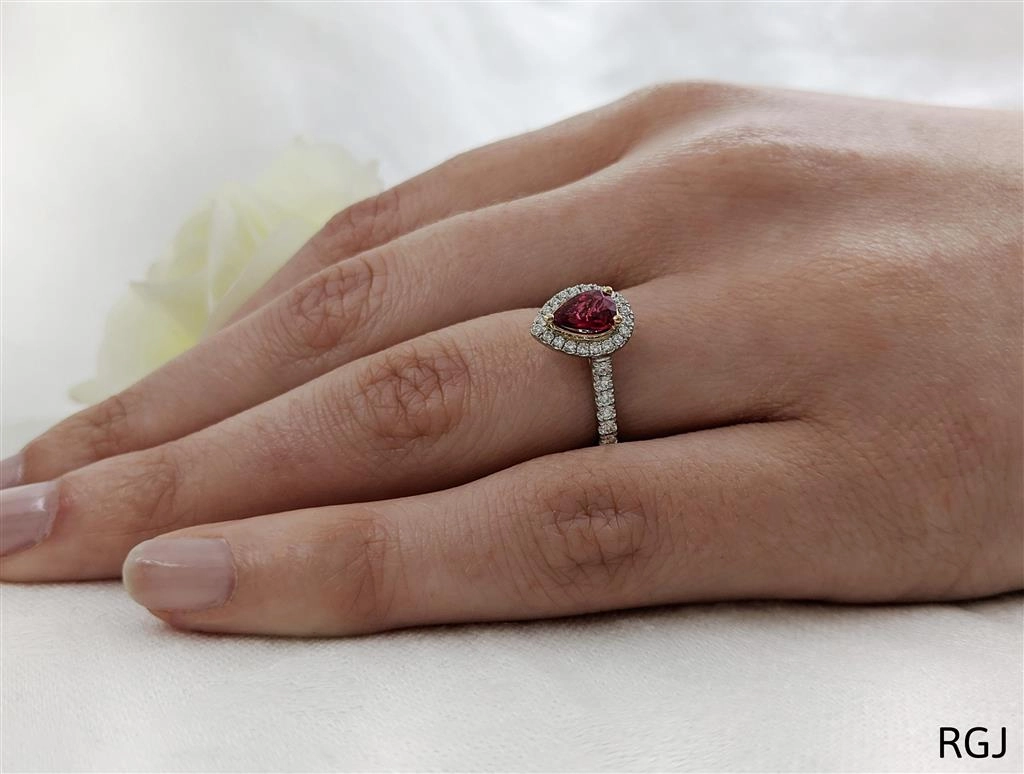 The Skye Platinum And 18ct Rose Gold 0.75ct Pear Cut Ruby Ring With 0.39ct Diamond Halo And Diamond Set Shoulders